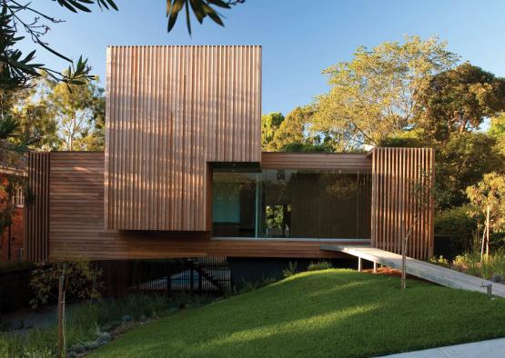 a wood house with a walkway and grass