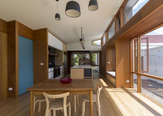 a dining table and chairs in a room with large windows