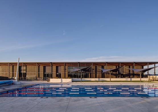 a swimming pool with a building and blue sky