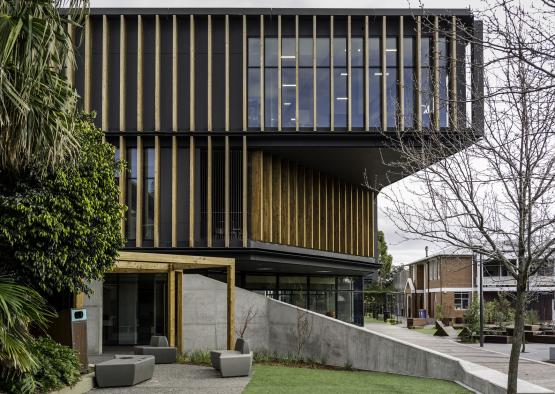 a building with a green lawn and trees