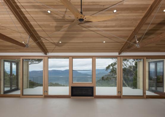 a room with a large fireplace and a ceiling fan