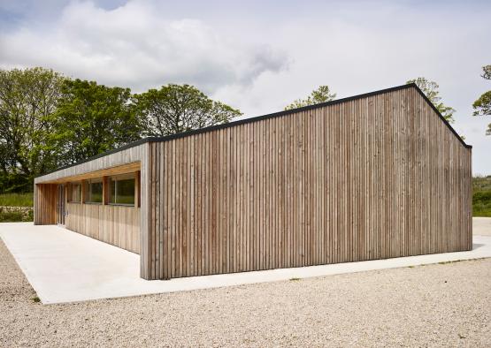 a building with a roof and trees in the background