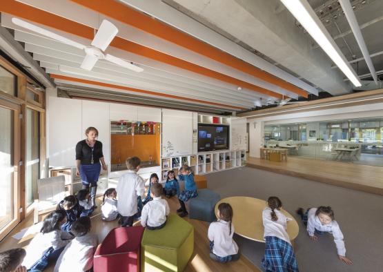 a group of children sitting on the floor in a classroom