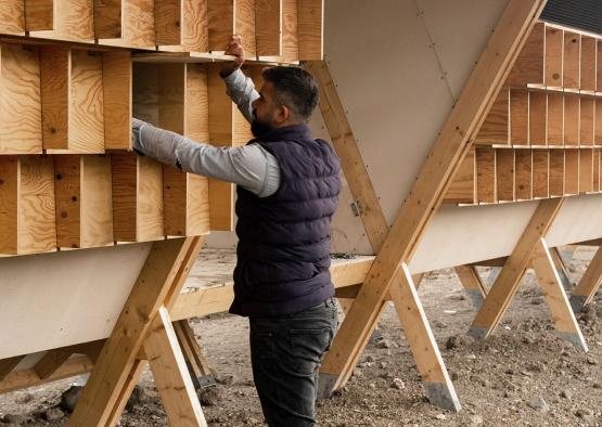 a man standing outside with a wooden shelf