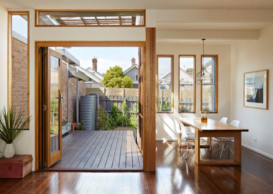 a dining table and chairs in a room with a deck and a patio