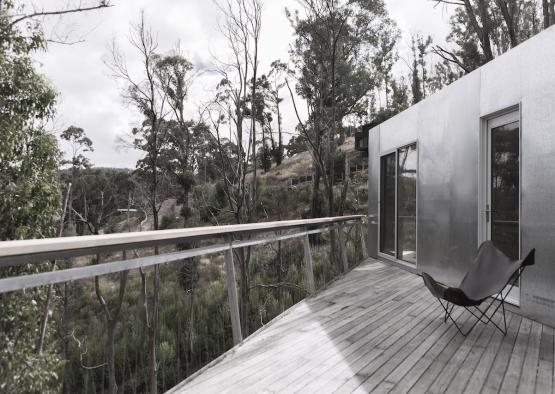 a chair on a deck overlooking trees