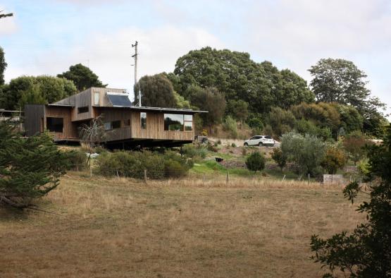 a house with a car parked in the middle of a field