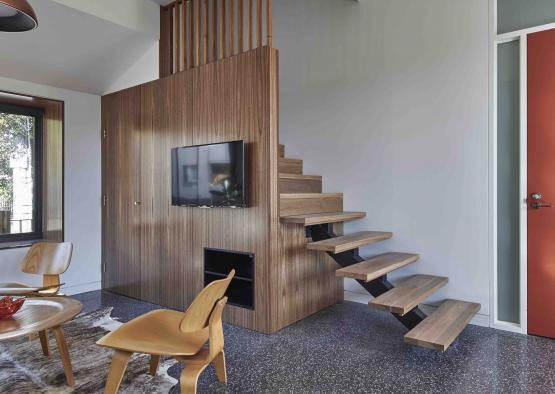 a living room with a staircase and a tv