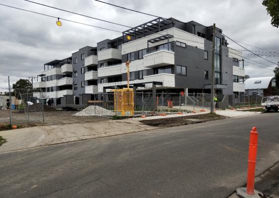 a building under construction with a road and power lines