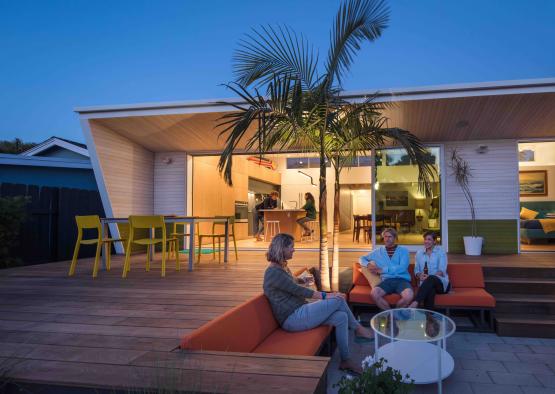 a group of people sitting on a couch outside of a house