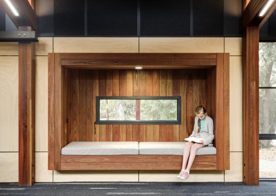 a girl sitting on a bench reading a book