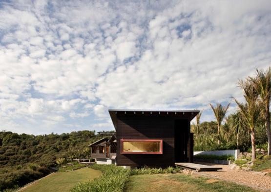 a house with a grassy hill and trees