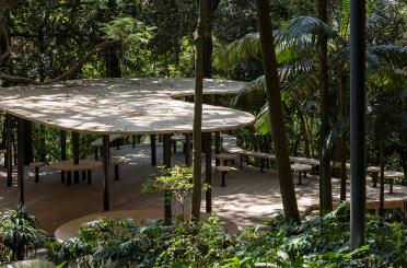 a picnic area with tables and benches in the woods