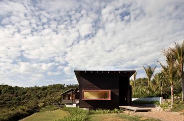 a house with a grassy hill and trees