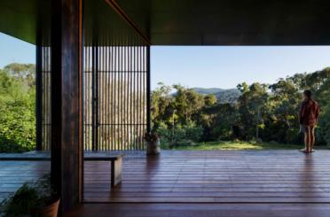 a wooden deck with a view of trees and mountains