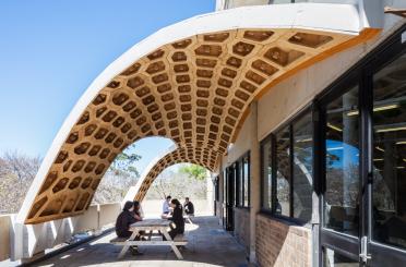 people sitting on a bench under a building